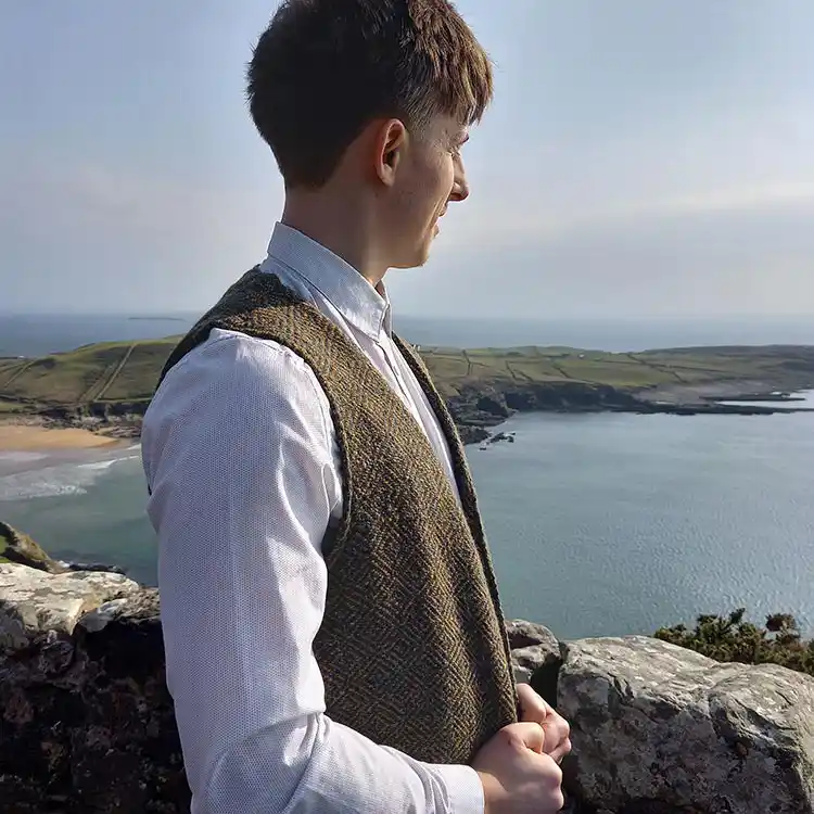 Young man wearing a tweed waistcoat standing by the shore in Kilcar, County Donegal.